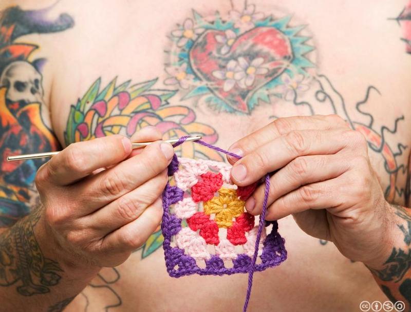 Mann med tatovering hekler. Foto.