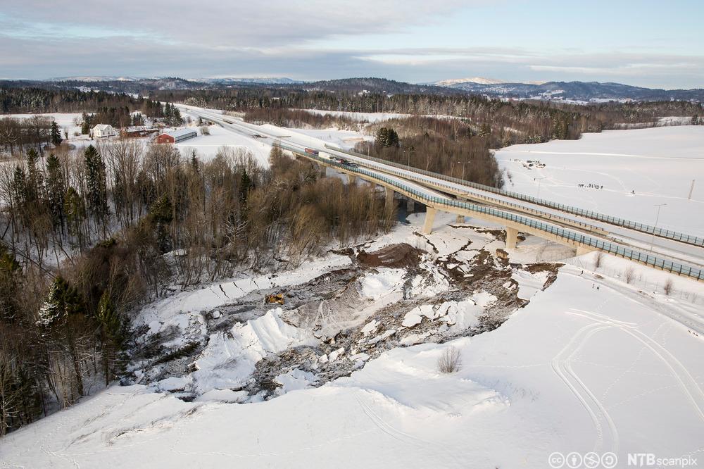 Vi ser en todelt bro i et snødekt landskap. Det er gått et skred under broa, og det ene kjørefeltet har delvis kollapset. Foto.