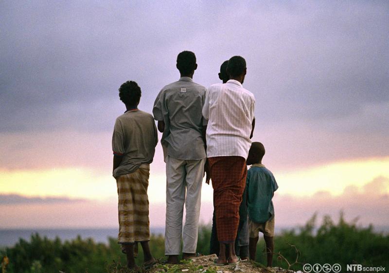En gruppe somaliere ser mot Det indiske hav mens de venter på amerikanske FN-tropper, 1992. Foto.
