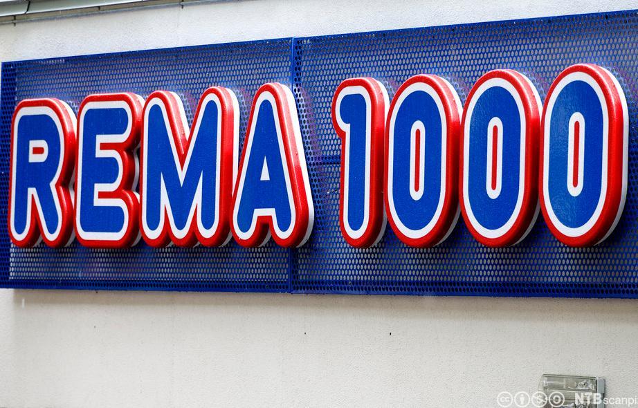 Foto av logoen til Rema 1000 på en vegg.