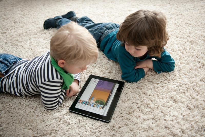 To barn spiller dataspill på en iPad. Foto.