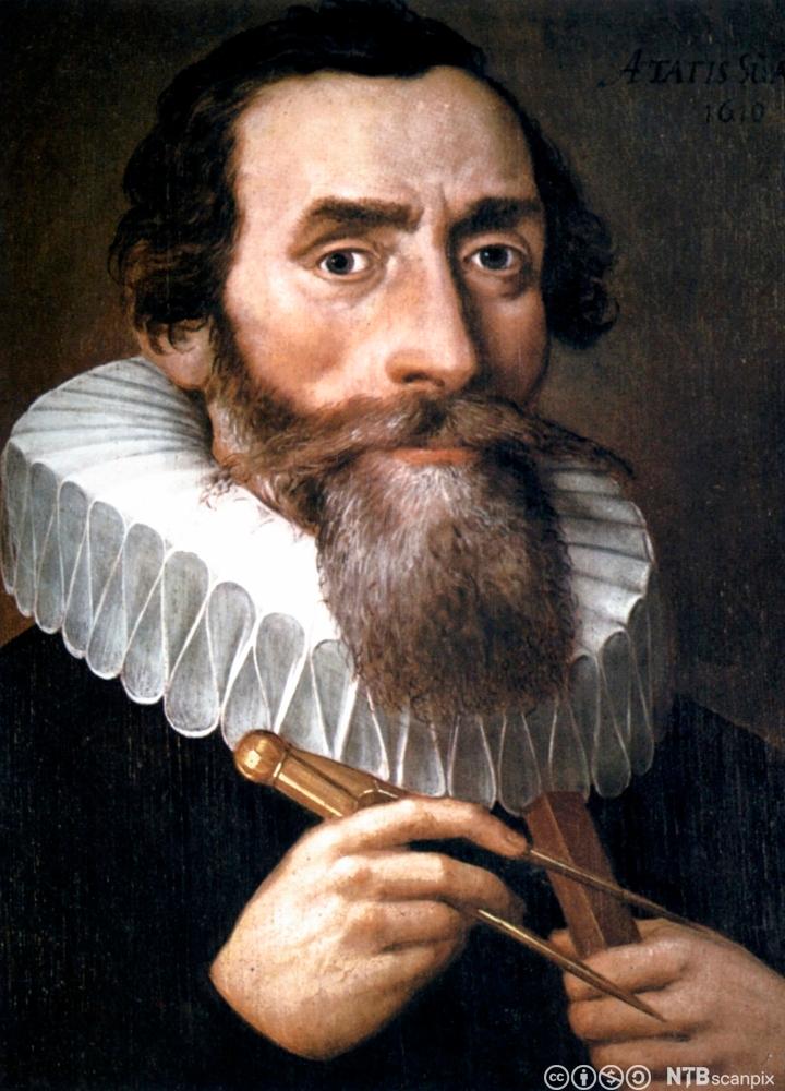 Portrett av Johannes Kepler. Han har langt skjegg, lange barter og stor pipekrage, og han holder en linjal og en passer. Maleri.