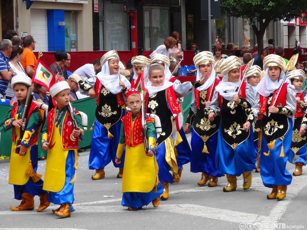 Barn i fargerike mauriske drakter under feiringen av Moros y cristianos, festival som feirer sameksistens mellom maurerne og de kristne. Foto.