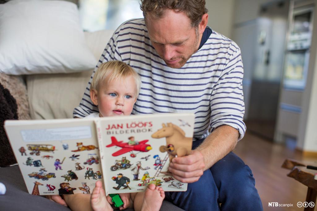 Pappa leser sammen med en liten gutt. Foto.