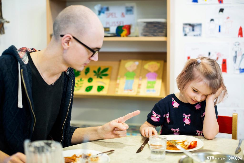 Mannlig pedagog kjefter på jente. Bilde.