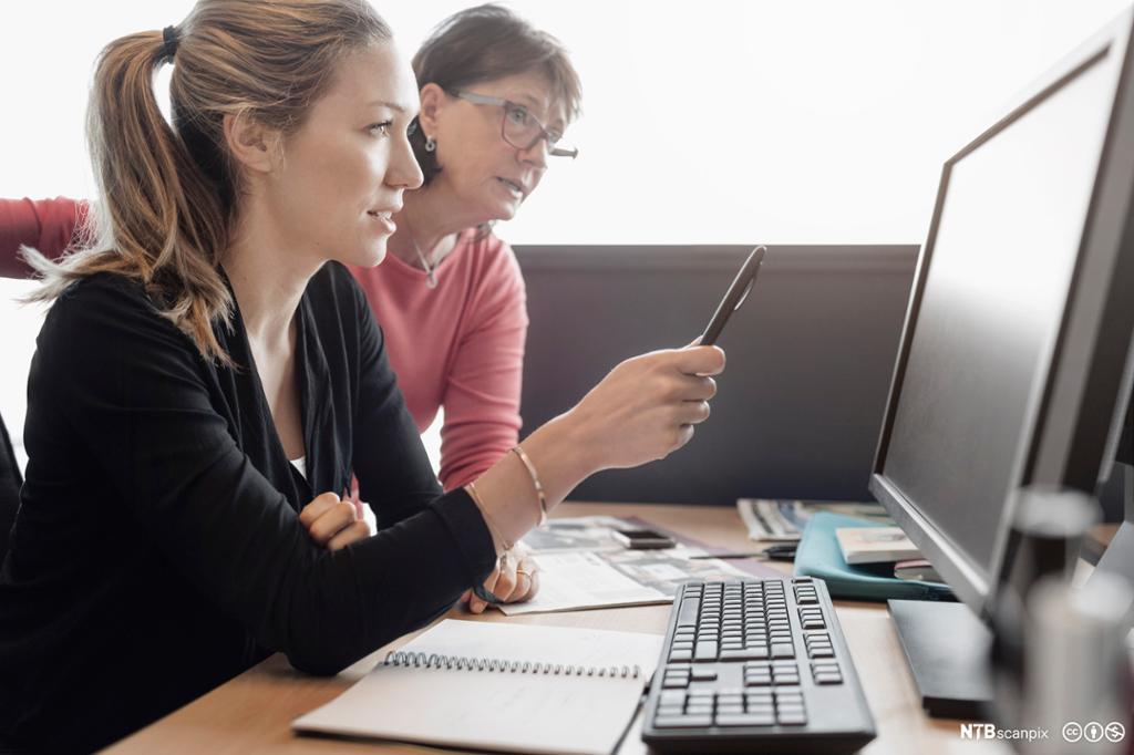 To kvinnelige kollegaer ser på en dataskjerm sammen. Foto.