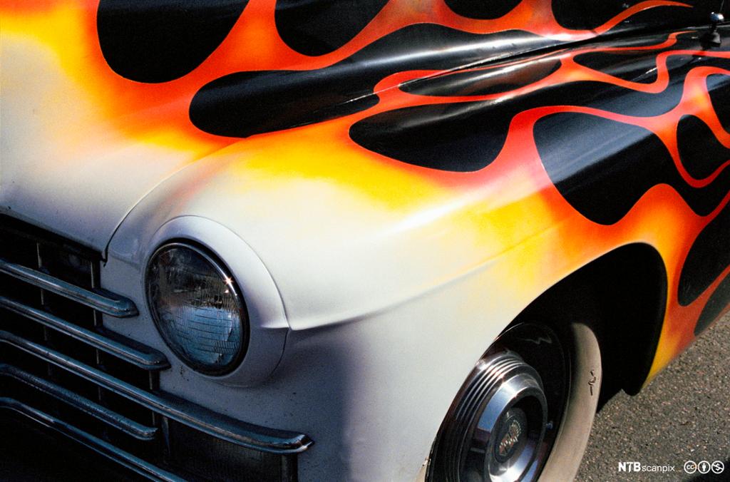 Bil med flammedekor på panseret. Foto.