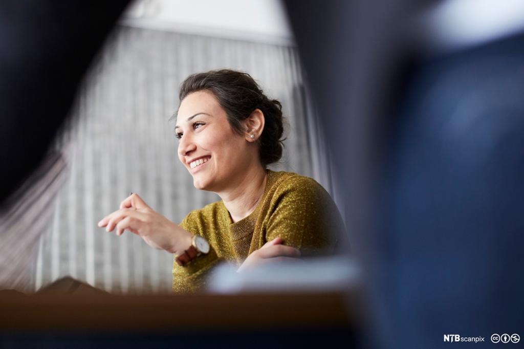 Smilende forretningskvinne på kreativt kontor. Bilde.