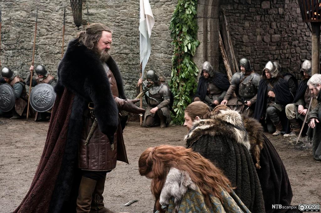 Lord Eddard og Lady Catelyn Stark,  fra TV-serien Game og Thrones, viser respekt for King Robert ved å knele. Foto.