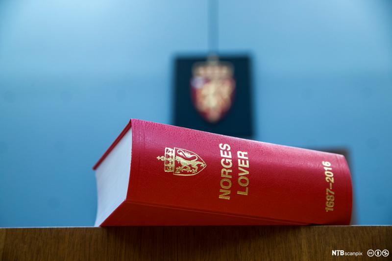 Bok med Norges lover ligger på en bordkant. Foto.