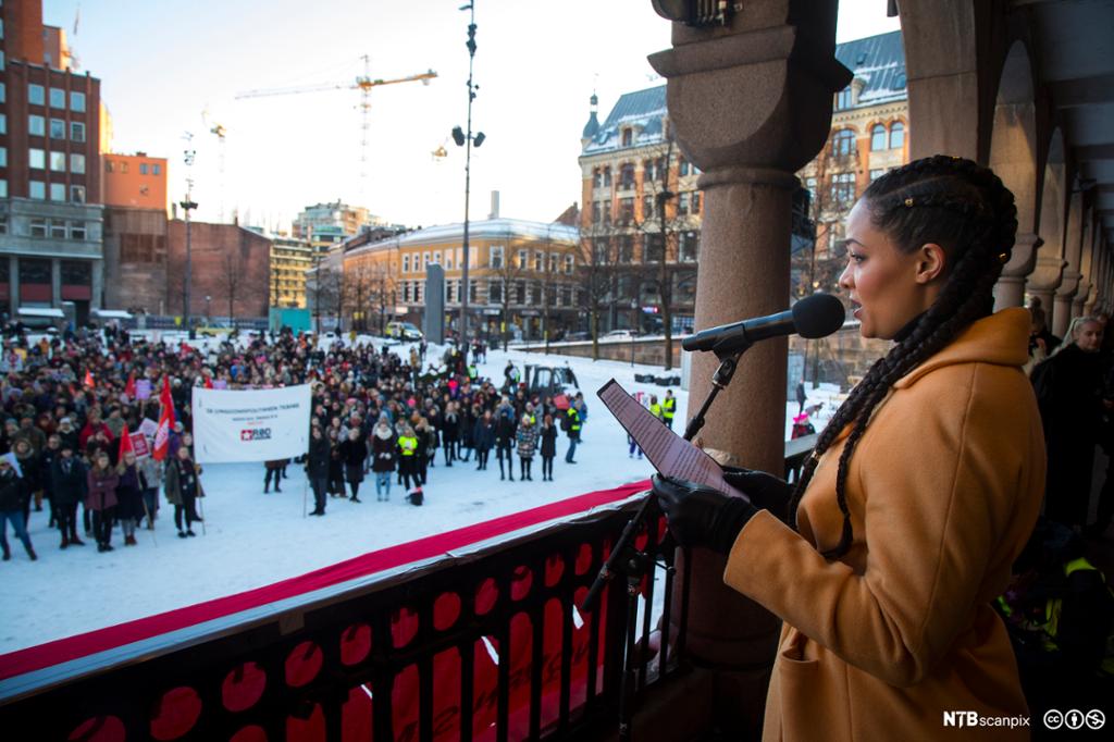 Skuespiller Iselin Shumba taler i mikrofon foran en folkemengde på Youngstorget. Foto.