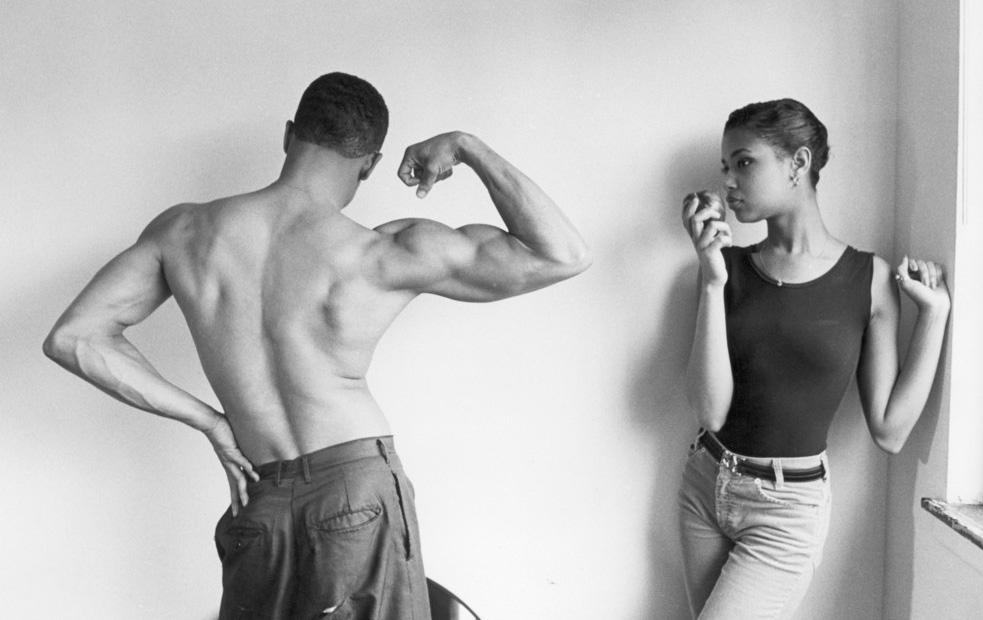 Gutt som viser musklene sine til ei jente. Foto.