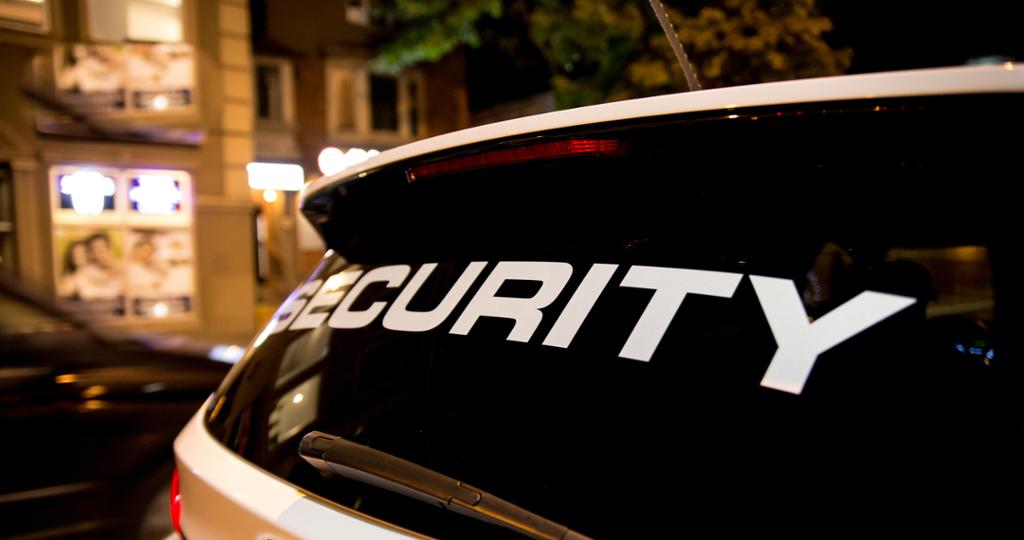 Nærbilete av ein patruljerande Security-bil om natta. Foto.