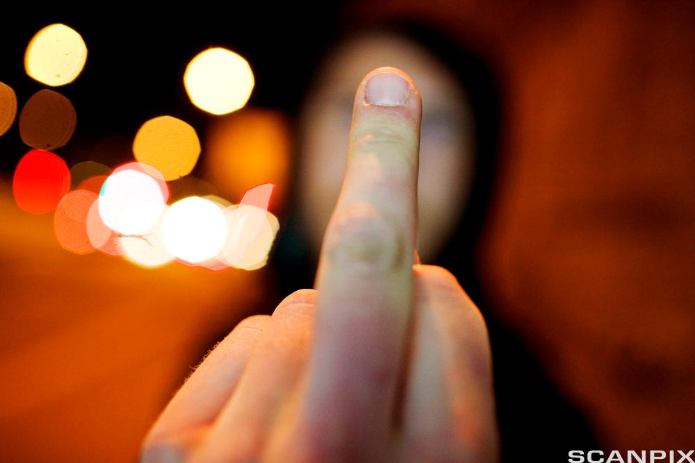 En person viser fingeren. Foto.