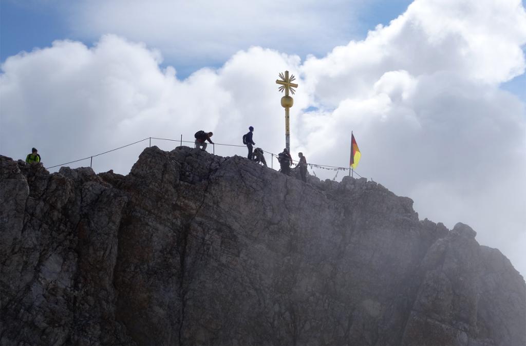 Ei gruppe vandrare som har nådd ein fjelltopp i dei tyske Alper. Avstandsbilde. Foto.
