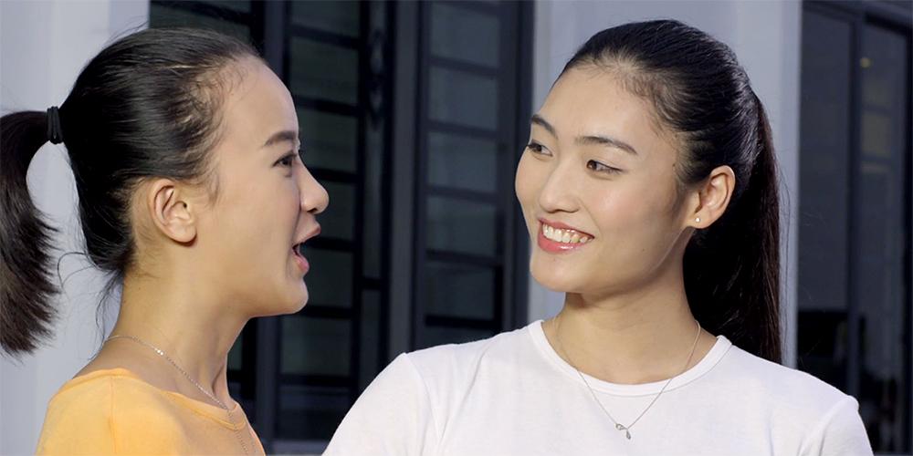 To unge kvinner fra Kina snakker sammen. Foto.