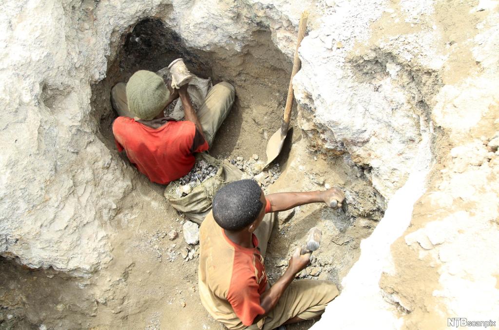 Unge arbeidere ved en koboltgruve i Kongo som bruker hammer og meisel for å finne mineralene. Foto. 