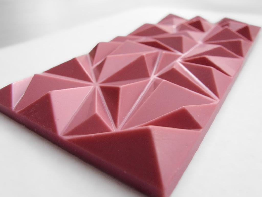 Rosa sjokoladeplate med dekorativt mønster. Foto.