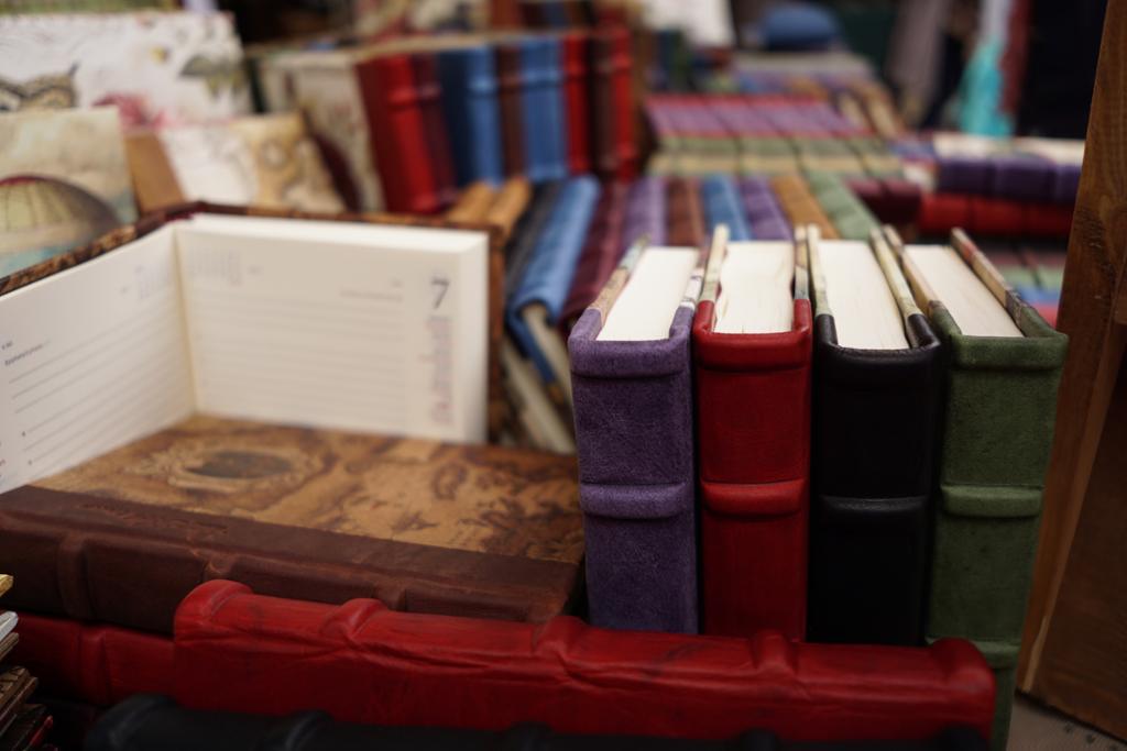 Fotografi av håndbundne bøker med permer i ulike farger.