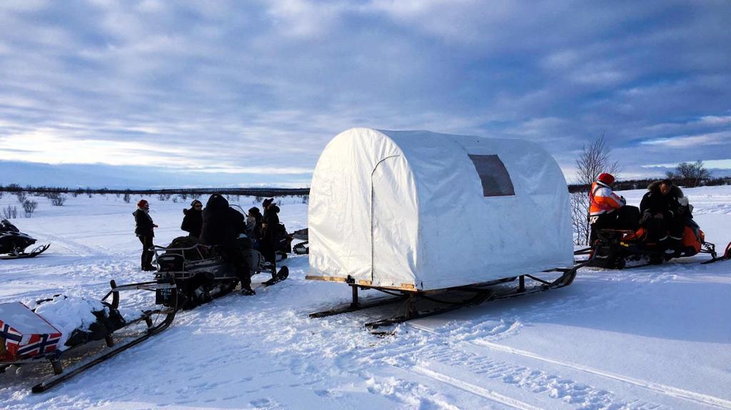 Snøskuter med telt på tilhengjaren. Foto.