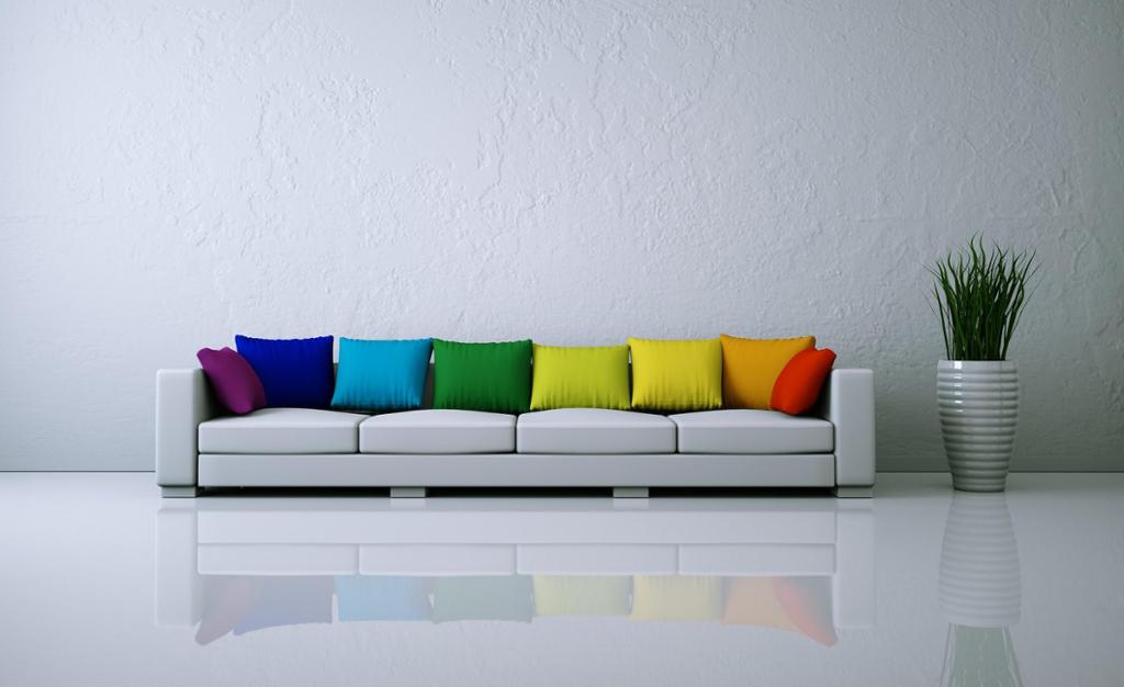 Kvit sofa med fargerike puter. Foto.