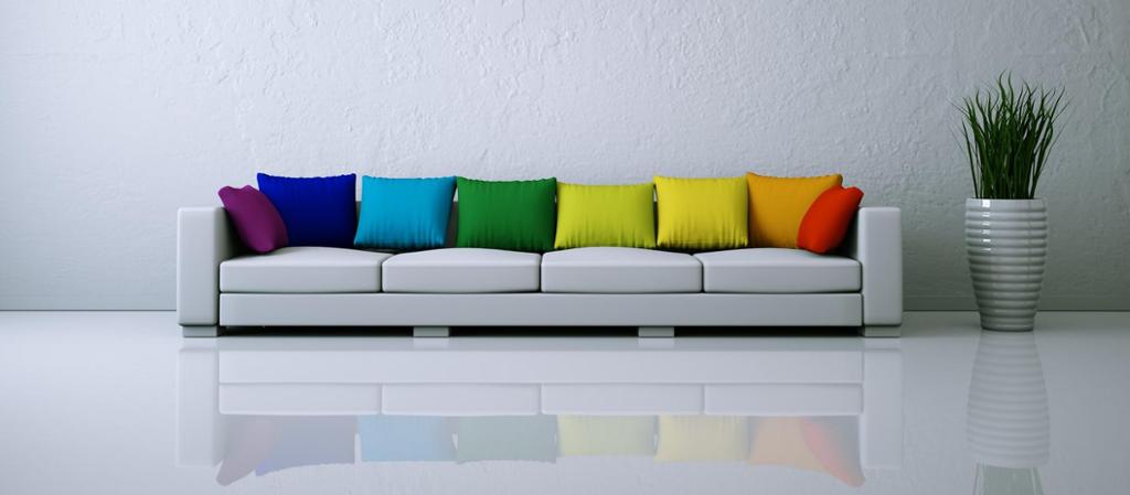 Hvit sofa med fargerike puter. Foto.