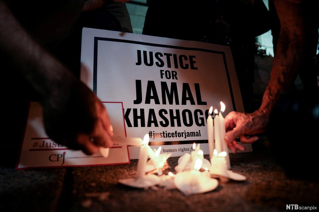 Candles are lit in front of a poster saying Justice for Jamal Khashoggi. 