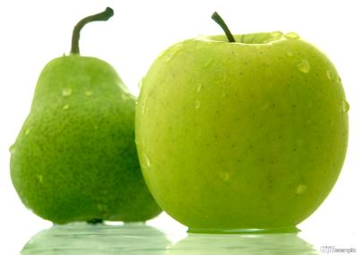 Ei grøn pære og eit grønt eple mot kvit bakgrunn. Foto.