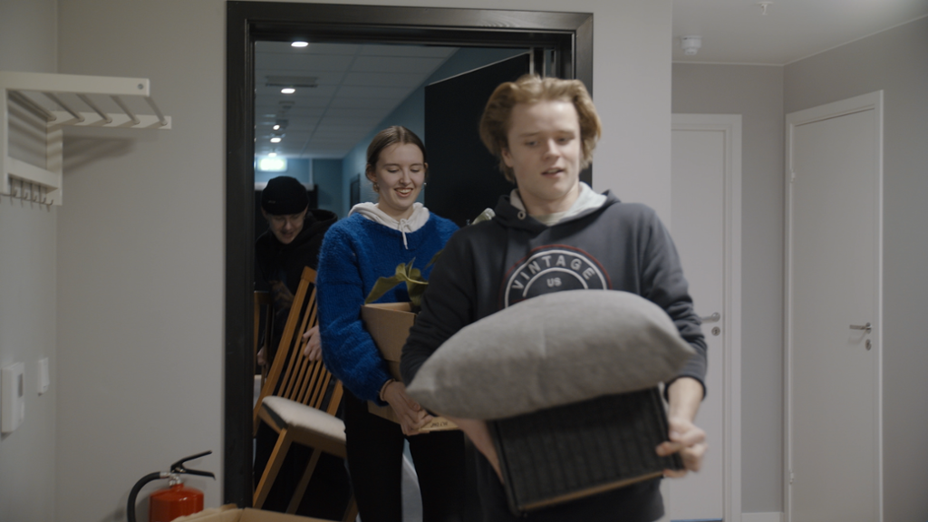 Ungdommer bærer på møbler inn i en leilighet