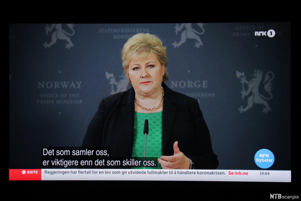 Bilde av en TV-skjerm der statsminister Erna Solberg sier at det som samler oss, er viktigere enn det som skiller oss. Foto.