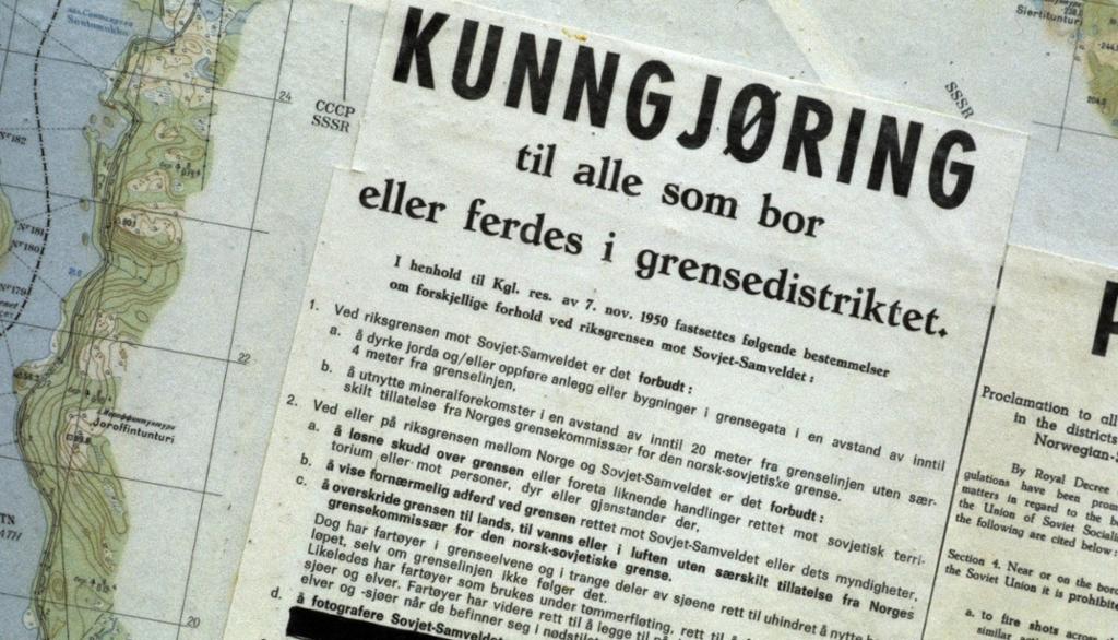 På eit kartutsnitt av norskegrensa ligg eit dokument med overskrifta "Kunngjøring til alle som bor eller ferdes i grensedistriktet". Foto.