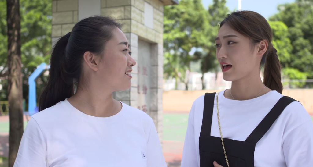 To kinesiske jenter snakker sammen i en park. Foto.