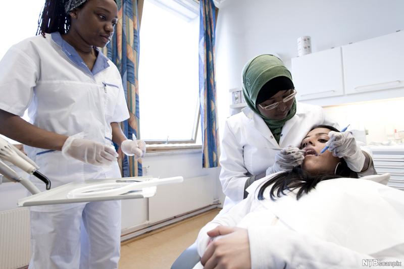 Elever på tannhelsesekretærutdanning undersøker pasient. Foto. 