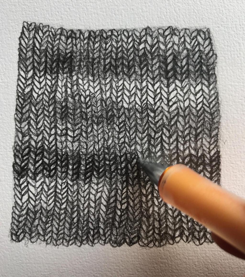 En stripet strikket lapp er tegnet i ulike gråtoner. Foto.